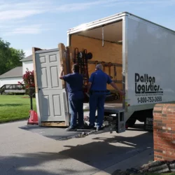 2 men loading door into delivery truck