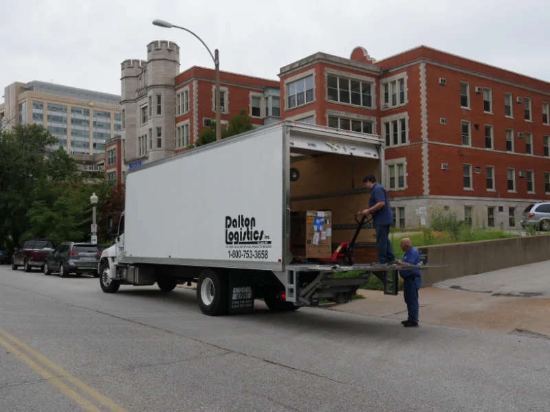 two men filling the back of the dalton logistics truck